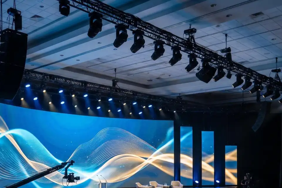 Illustration: a ballroom with a curved LED wall and moving lights on truss